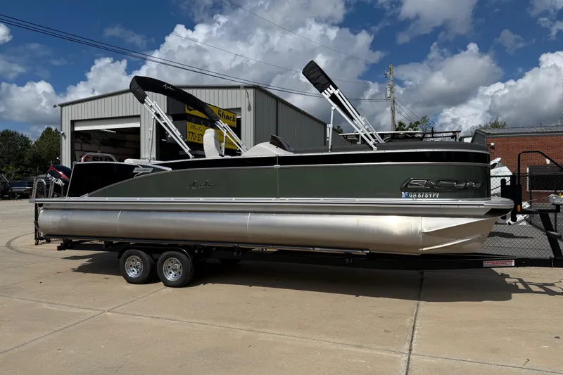 Slide: The Image of 2022 Avalon Catalina VRL 25' pontoon boat on trailer, parked outside a garage. - 10