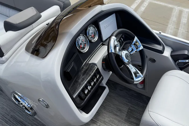 Slide: The Image of 2022 Avalon Catalina VRL 25' boat dashboard with chrome steering wheel and gauges. - 22