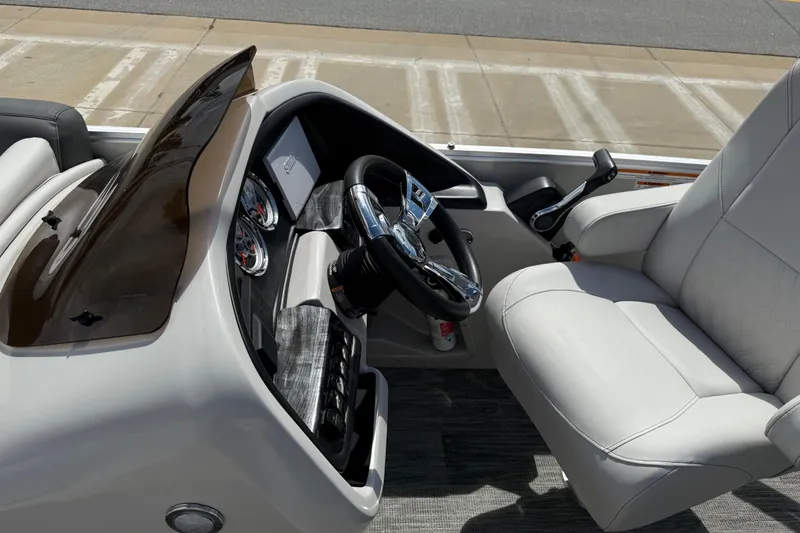 Slide: The Image of Interior of 2022 Avalon Catalina VRL boat, featuring steering console and plush seating. - 42