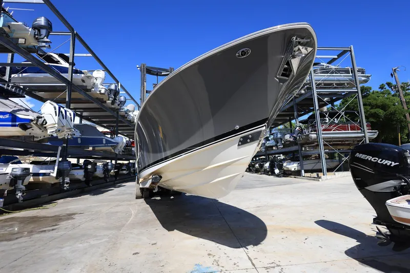 Slide: The Image of 2022 Pursuit S 288 Sport boat in storage, surrounded by other boats and engines. - 1