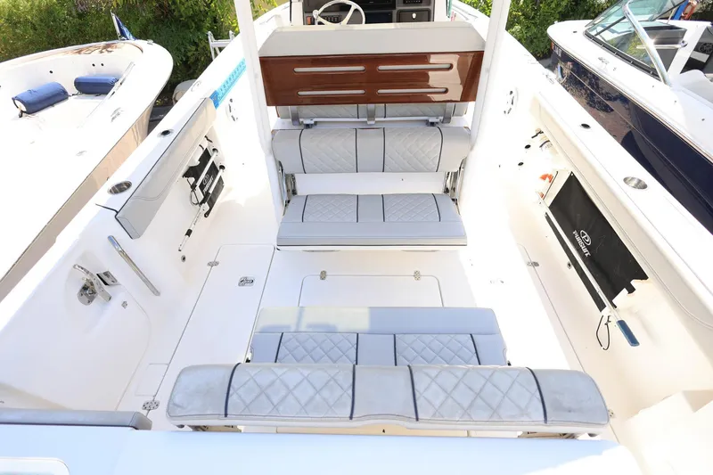 Slide: The Image of 2022 Pursuit S 288 Sport boat interior with cushioned seating and sleek design. - 12