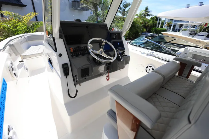 Slide: The Image of 2022 Pursuit S 288 Sport boat interior with steering wheel and seating. - 17