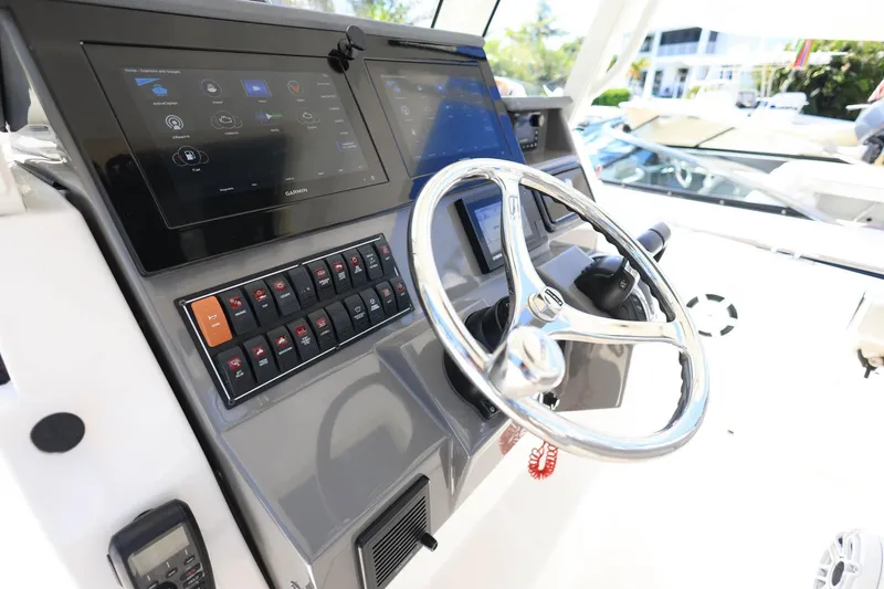 Slide: The Image of 2022 Pursuit S 288 Sport boat dashboard with steering wheel and control panel. - 18