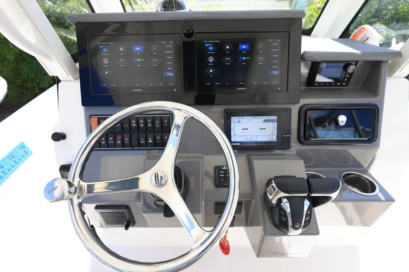 Slide: The Image of Helm of 2022 Pursuit S 288 Sport boat with advanced navigation displays and controls. - 19