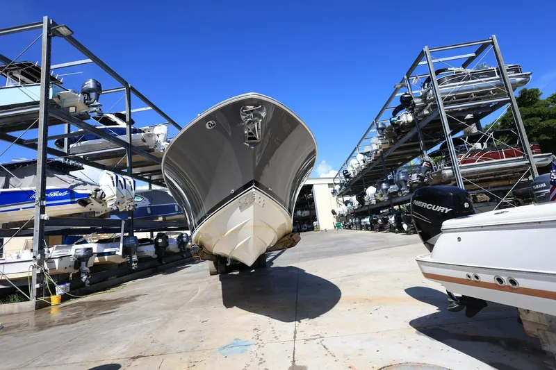 Slide: The Image of 2022 Pursuit S 288 Sport boat in dry storage facility under clear blue sky. - 2