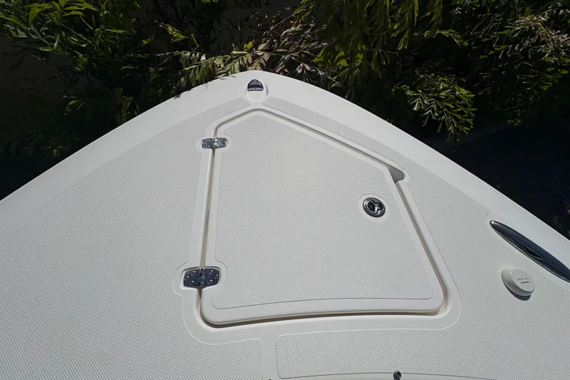 Slide: The Image of 2022 Pursuit S 288 Sport boat deck with storage hatch and greenery. - 29