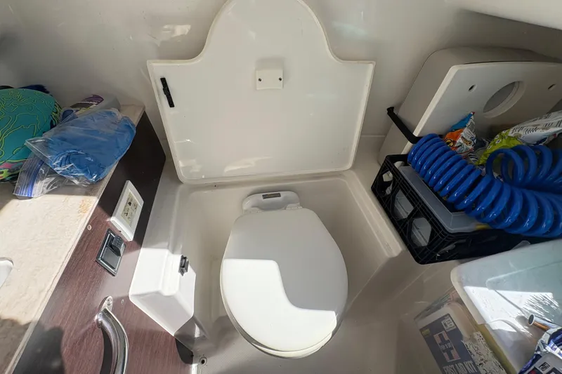 Slide: The Image of 2022 Pursuit S 288 Sport boat interior with compact toilet and storage area. - 33