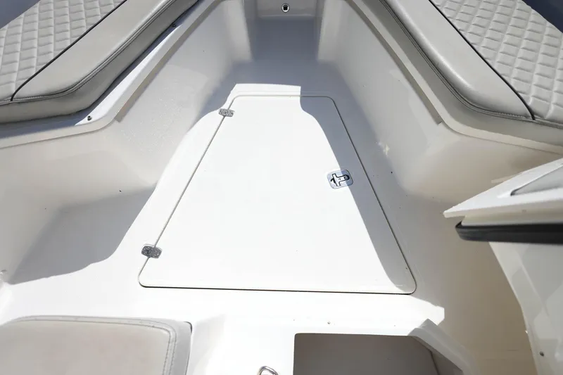 Slide: The Image of 2022 Pursuit S 288 Sport boat interior with cushioned seating and storage hatch. - 34