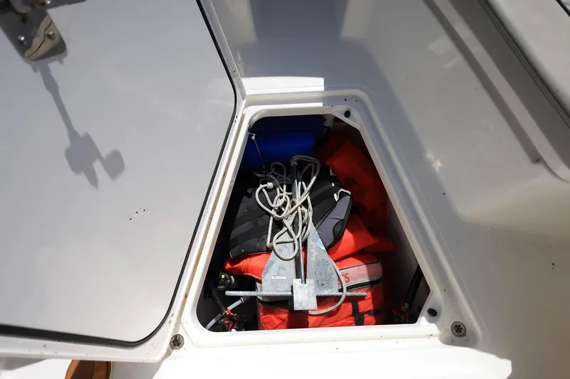 Slide: The Image of Open storage compartment on 2022 Pursuit S 288 Sport boat with life jackets and anchor. - 35
