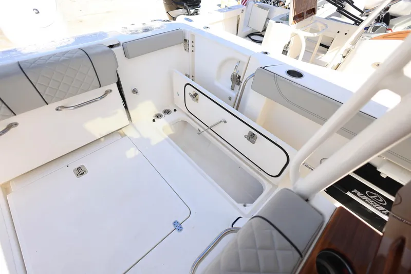 Slide: The Image of 2022 Pursuit S 288 Sport boat interior with storage compartments and cushioned seating. - 39