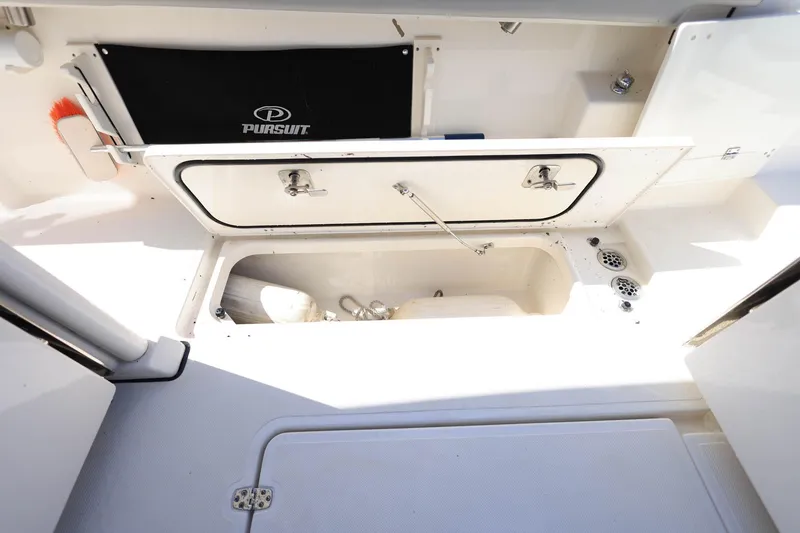 Slide: The Image of 2022 Pursuit S 288 Sport boat storage compartment with open hatch and visible equipment. - 40