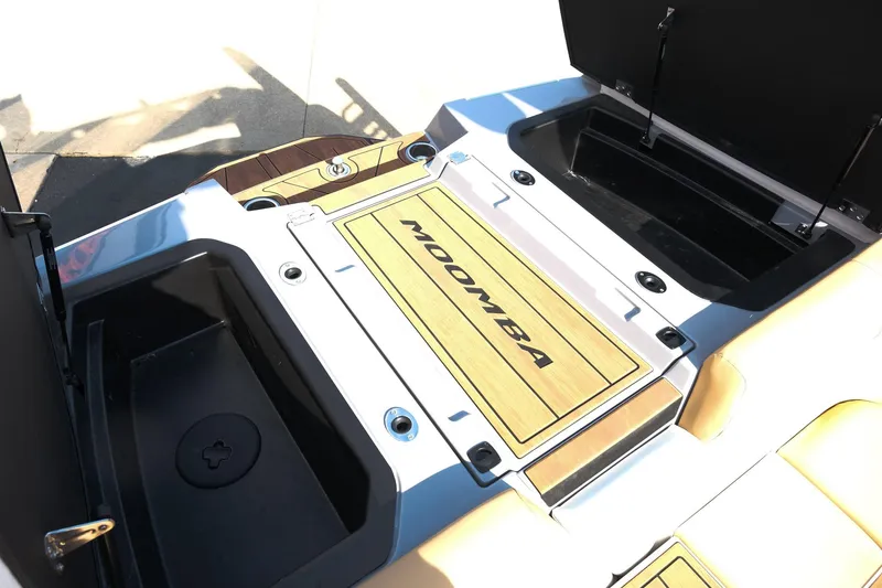 Slide: The Image of 2023 Moomba Mondo boat interior with open storage compartments and branded flooring. - 11