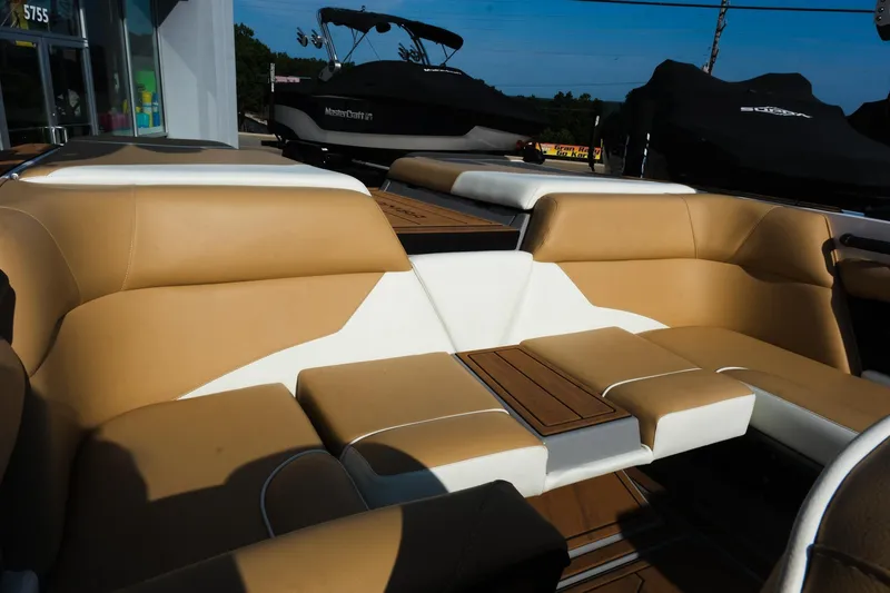 Slide: The Image of 2023 Moomba Mondo boat interior with tan and white seating, wooden accents. - 17