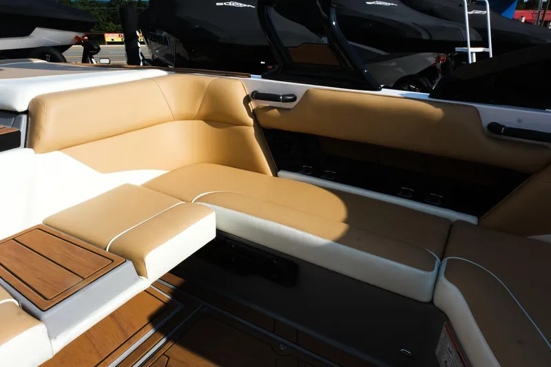 Slide: The Image of 2023 Moomba Mondo boat interior with tan and white seating, featuring wood accents. - 18