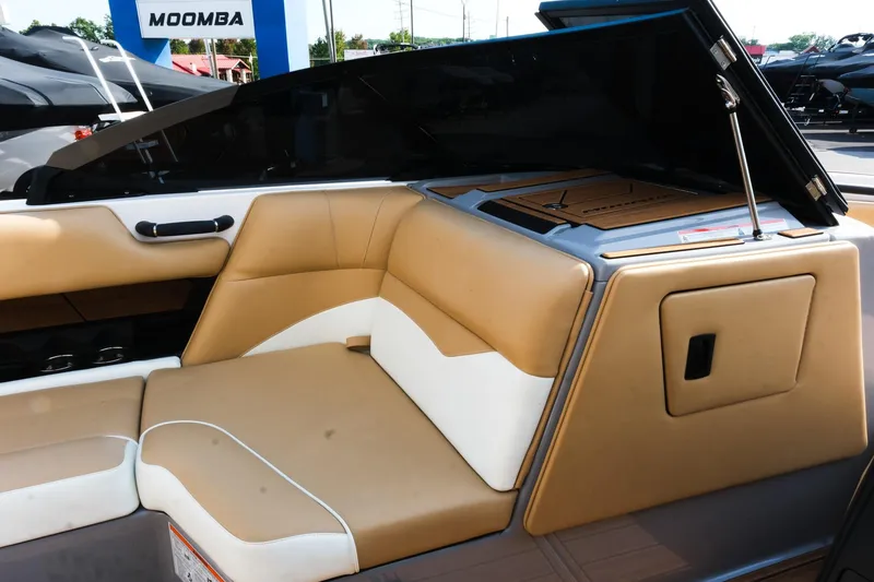 Slide: The Image of 2023 Moomba Mondo boat interior with tan and white seating, open storage compartment. - 19