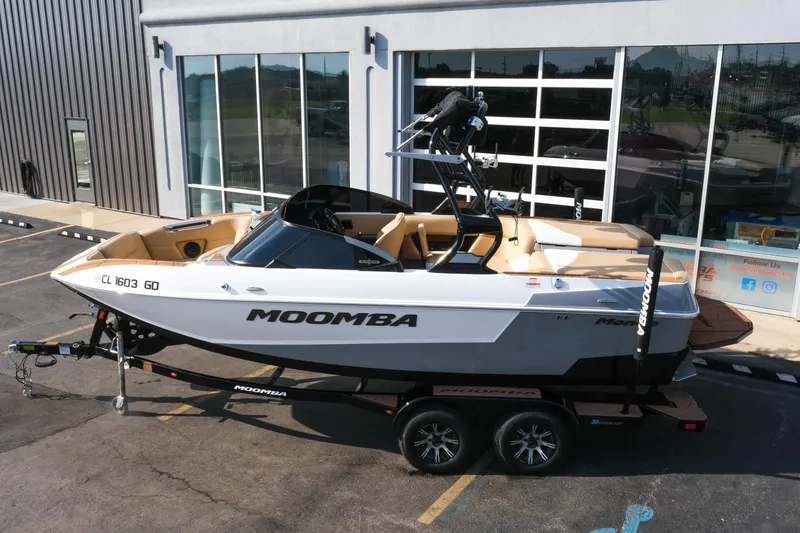 Slide: The Image of 2023 Moomba Mondo boat on trailer, parked outside a building. - 2