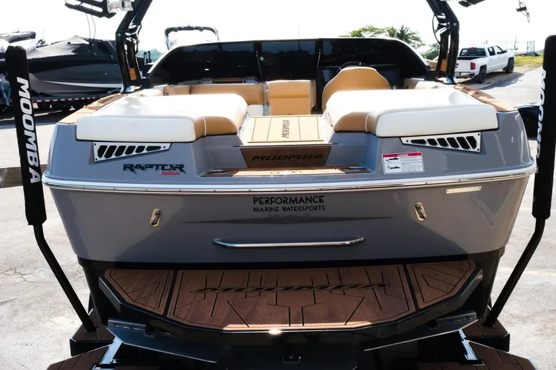 Slide: The Image of 2023 Moomba Mondo boat rear view with Raptor engine, beige seating, and teak deck. - 4
