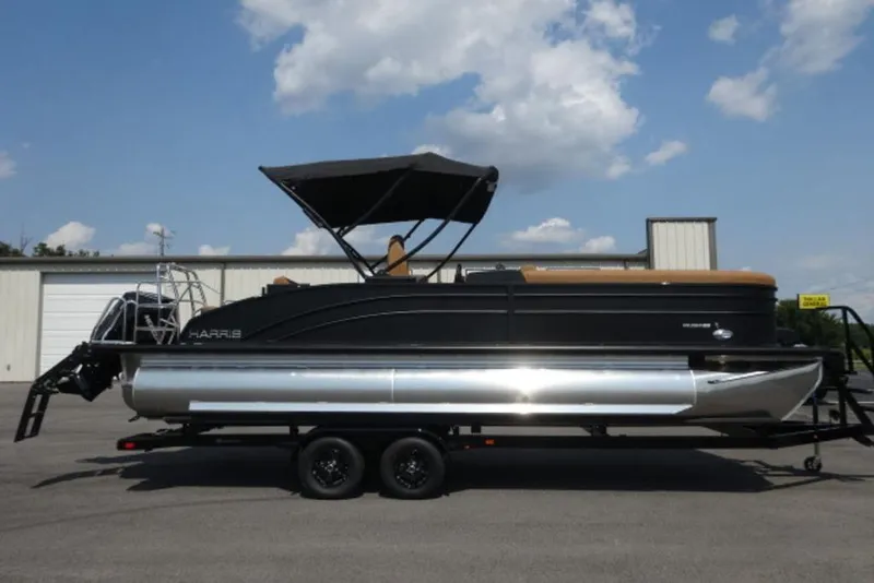 The Image of 2025 Harris Cruiser 250 LUX pontoon boat on trailer, parked outdoors. - 0