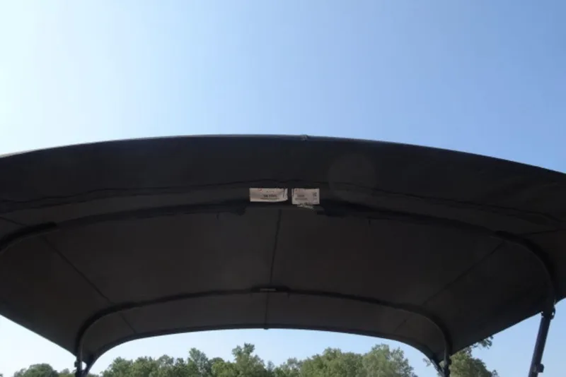 Slide: The Image of 2025 Harris Cruiser 250 LUX boat canopy under clear blue sky. - 16