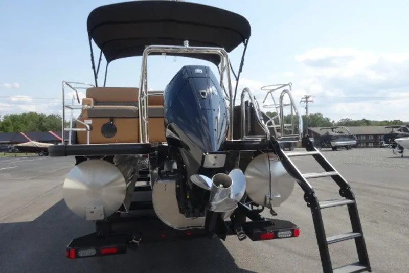 Slide: The Image of 2025 Harris Cruiser 250 LUX pontoon boat with outboard motor and ladder, rear view. - 2