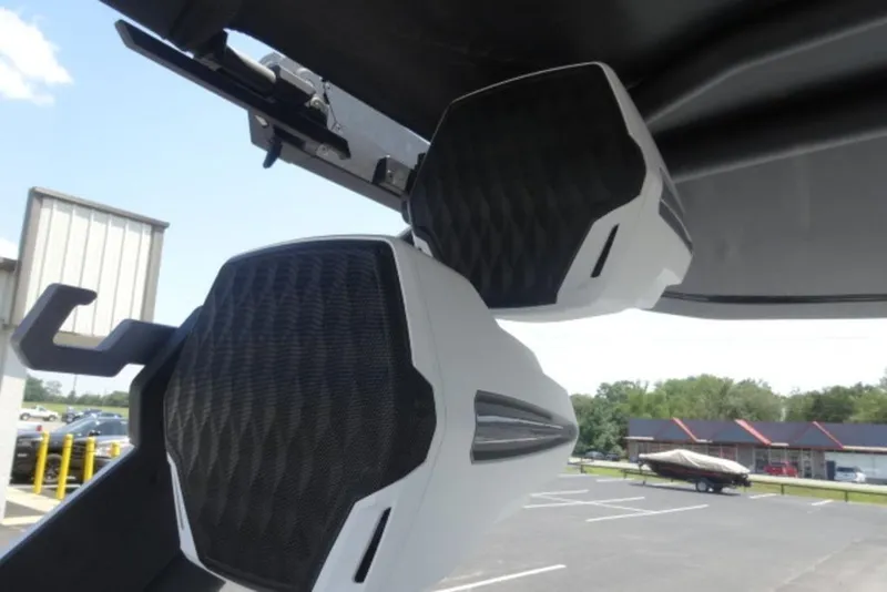 Slide: The Image of 2026 Malibu 23 MXZ boat speakers, mounted under a canopy, in a parking lot. - 5