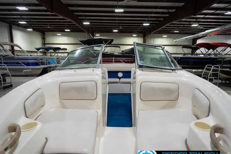 Slide: The Image of 1995 Sea Ray 175 Bow Rider boat interior in a showroom, featuring white and blue seating. - 16