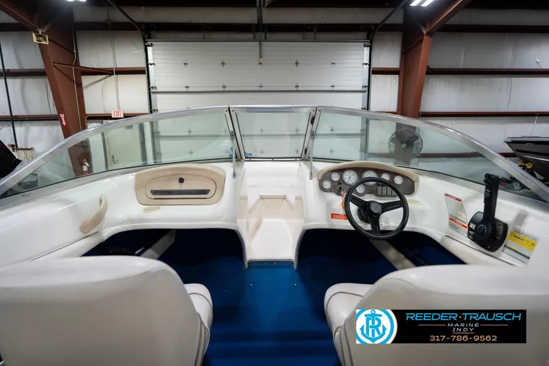 Slide: The Image of 1995 Sea Ray 175 Bow Rider interior with white seats and blue carpet in a showroom. - 20
