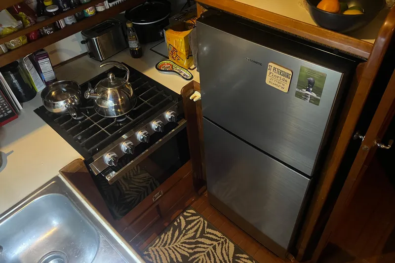 Slide: The Image of Compact kitchen in 1987 Marine Trader Sundeck with stove, fridge, and sink. - 11