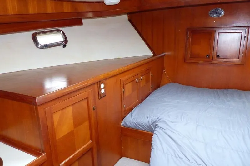 Slide: The Image of 1987 Marine Trader Sundeck cabin with wooden interior and cozy bed. - 13
