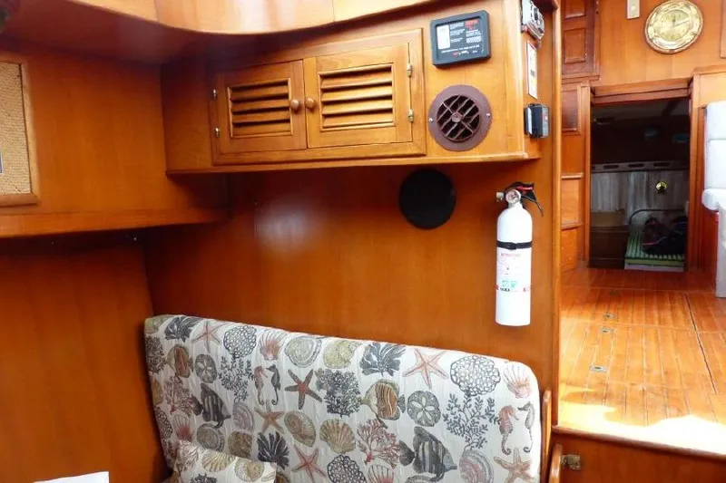 Slide: The Image of 1987 Marine Trader Sundeck interior with wooden cabinetry, floral upholstery, and safety equipment. - 16