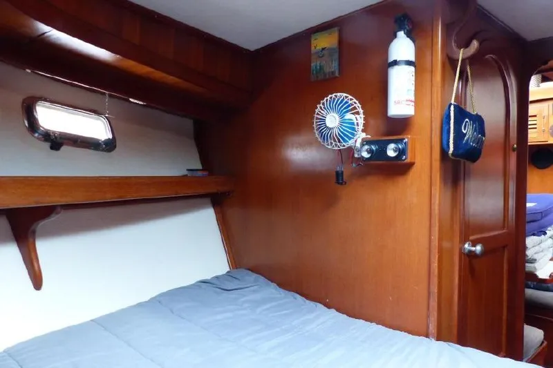 Slide: The Image of Cozy cabin interior of 1987 Marine Trader Sundeck with wooden paneling and small fan. - 17