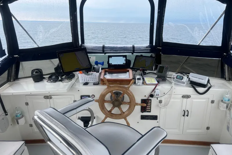 Slide: The Image of Helm of 1987 Marine Trader Sundeck yacht with navigation equipment and ocean view. - 24