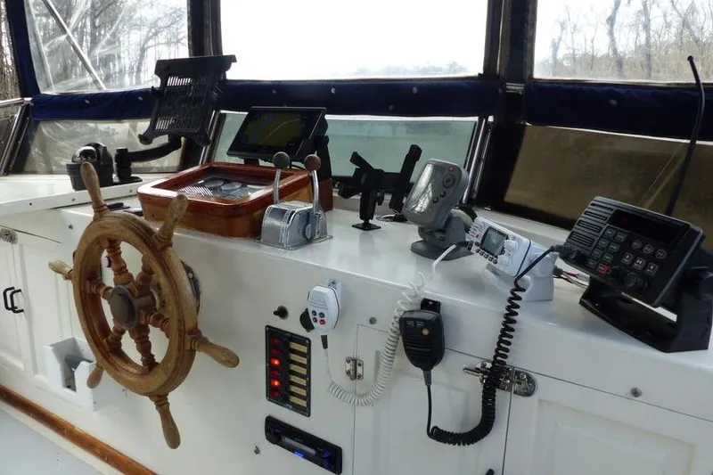 Slide: The Image of 1987 Marine Trader Sundeck helm with wooden wheel and navigation equipment. - 26