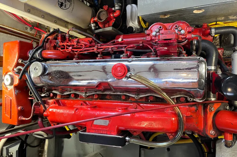 Slide: The Image of Engine of a 1987 Marine Trader Sundeck, featuring red and chrome components. - 28