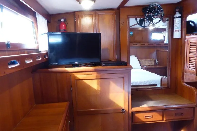 Slide: The Image of 1987 Marine Trader Sundeck interior with wood paneling, TV, and cozy cabin space. - 31