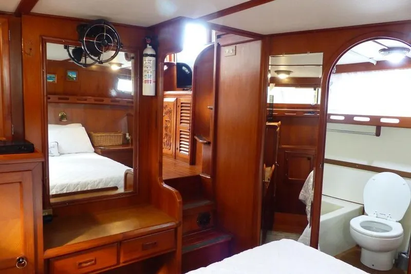 Slide: The Image of 1987 Marine Trader Sundeck interior with wooden finish, bed, and bathroom. - 32