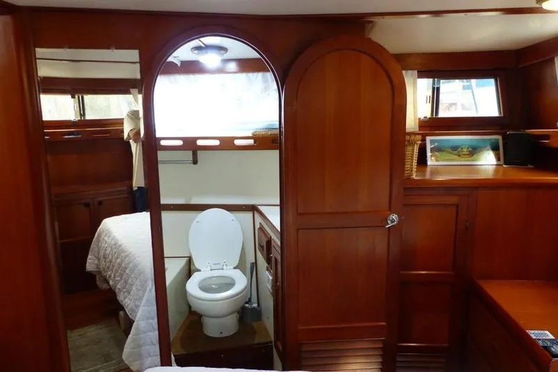 Slide: The Image of 1987 Marine Trader Sundeck interior with wooden cabinetry and bathroom. - 33