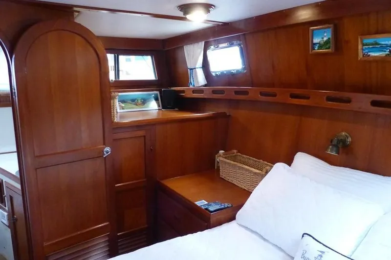 Slide: The Image of Cozy cabin interior of 1987 Marine Trader Sundeck with wooden furnishings and nautical decor. - 34