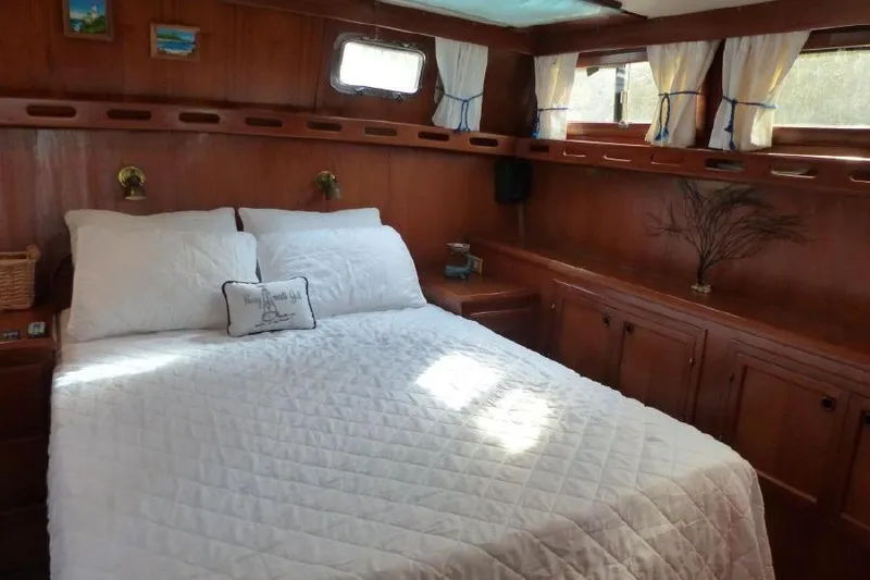 Slide: The Image of Cozy bedroom in 1987 Marine Trader Sundeck yacht with wood paneling and white bedding. - 38