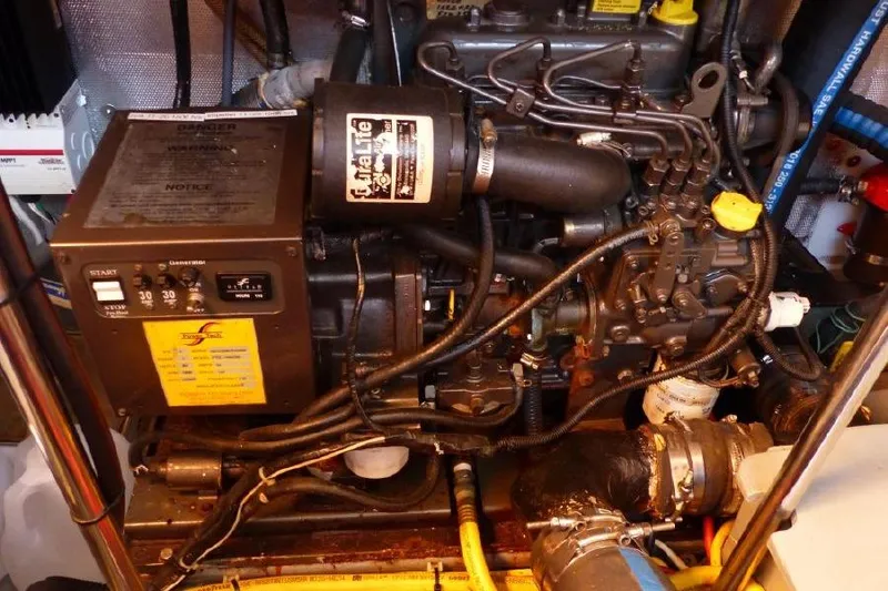 Slide: The Image of Engine room of 1987 Marine Trader Sundeck boat, showcasing mechanical components and wiring. - 42