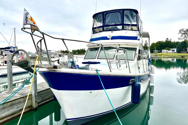 Slide: The Image of 1987 Marine Trader Sundeck boat docked in a serene marina setting. - 5