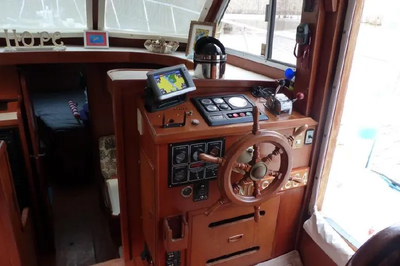 Slide: The Image of 1987 Marine Trader Sundeck helm with wooden wheel and navigation equipment. - 9