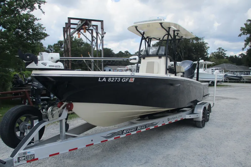 Slide: The Image of 2016 BlackJack 256 Bay boat on trailer, parked outdoors with trees in background. - 1