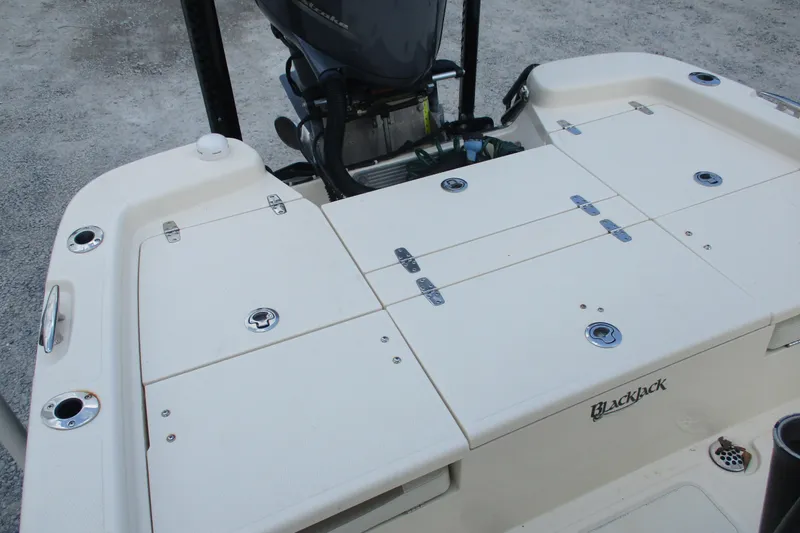 Slide: The Image of 2016 BlackJack 256 Bay boat deck with storage compartments and motor. - 13