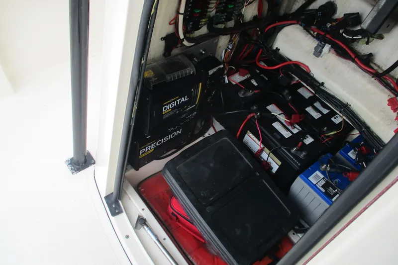Slide: The Image of 2016 BlackJack 256 Bay boat battery compartment with wiring and chargers. - 22