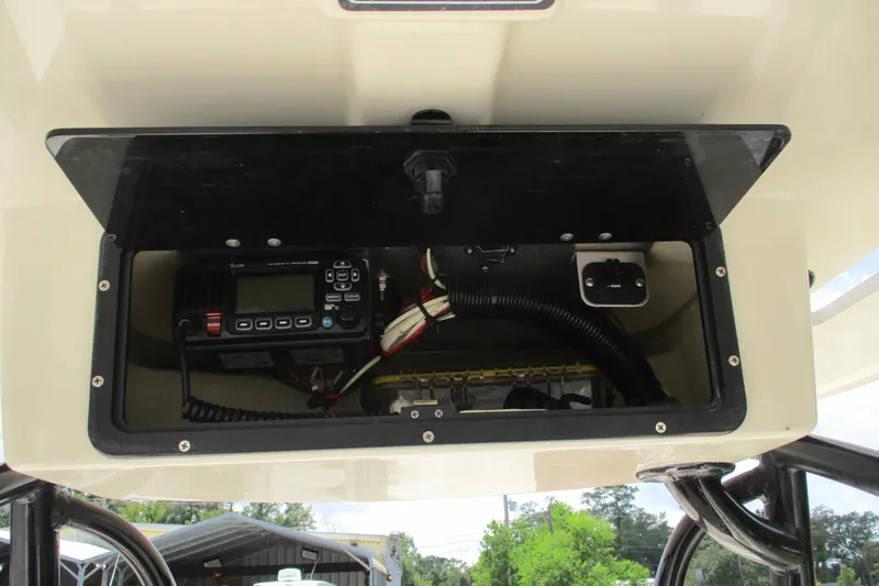 Slide: The Image of 2016 BlackJack 256 Bay boat electronics compartment with radio and wiring. - 26