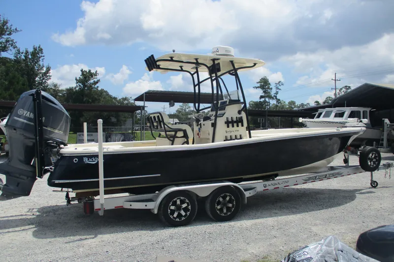 Slide: The Image of 2016 BlackJack 256 Bay boat on trailer with Yamaha outboard motor, parked outdoors. - 4