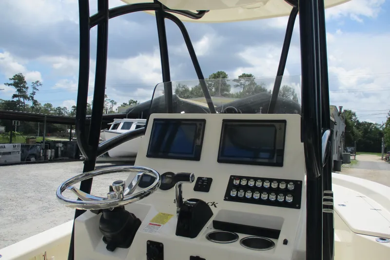Slide: The Image of 2016 BlackJack 256 Bay boat dashboard with steering wheel and control panels. - 7