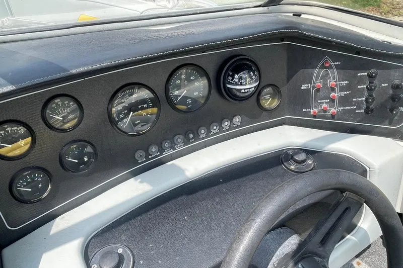 Slide: The Image of 1988 Donzi Open Bow dashboard with gauges and controls, featuring a steering wheel and compass. - 12