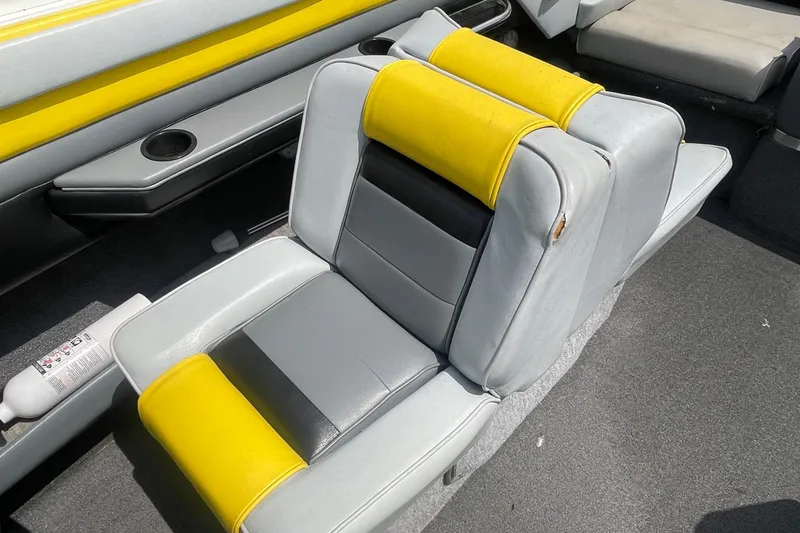Slide: The Image of 1988 Donzi Open Bow boat interior with gray and yellow seating, cup holders, and fire extinguisher. - 13